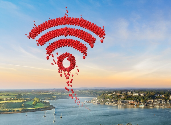 Red balloons creating a wifi-logo over a seascape