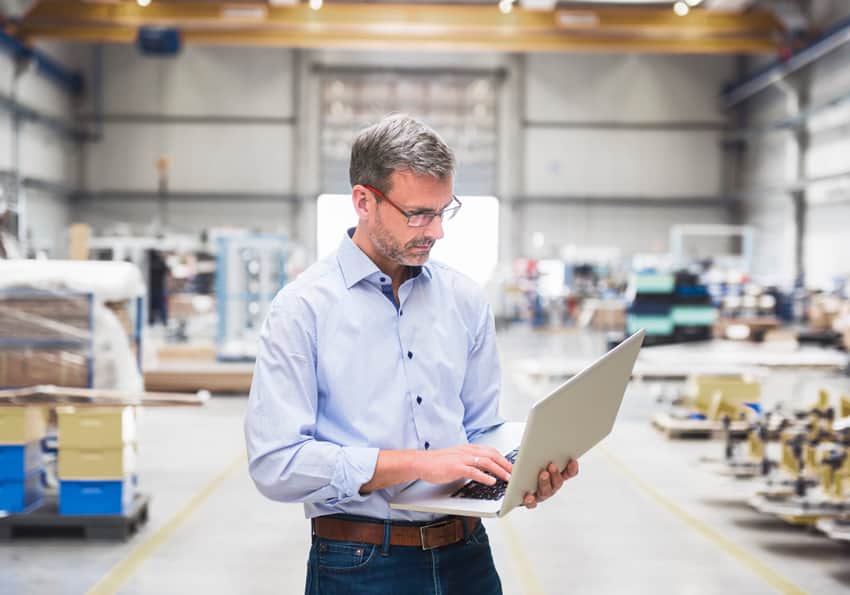 Man looking at laptop in warehouse