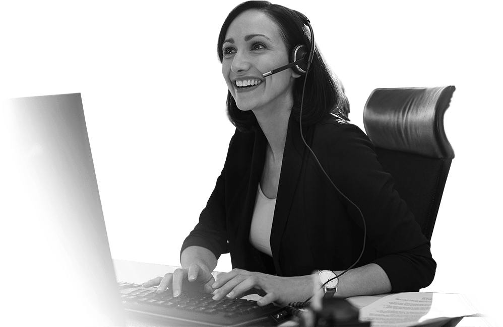 Female professional at her desk on a call using a handsfree headset sat in front of her computer