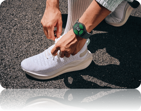 Person typing their shoes lace while wearing Galaxy Watch