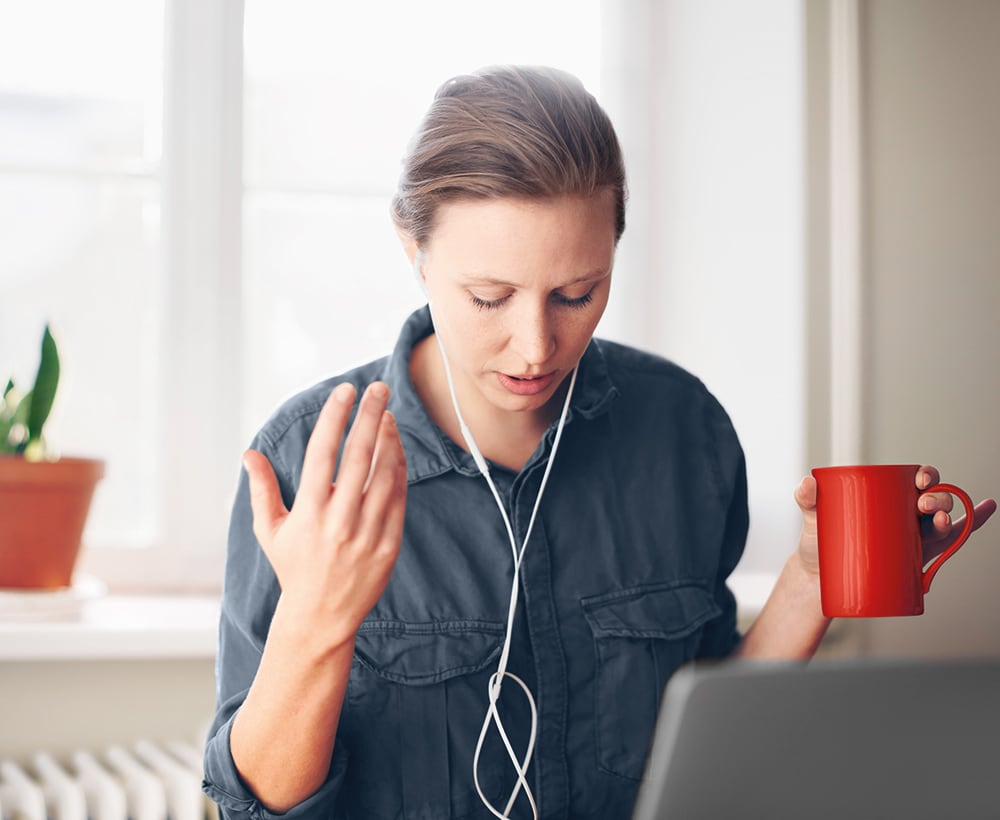 woman wearing earphones on laptop