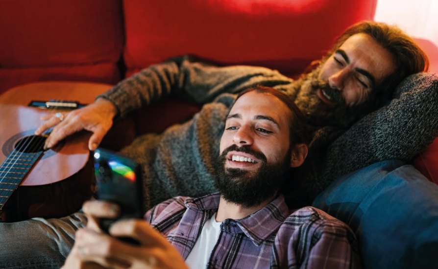 Two bearded men lounging on a sofa