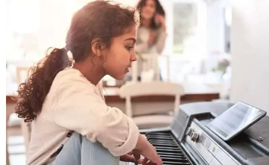 YOung girl playing a keyboard.