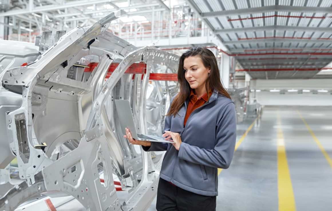 Engineer working on laptop in large facility