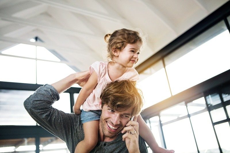 Better connections Dad with daughter on shoulders while on a call
